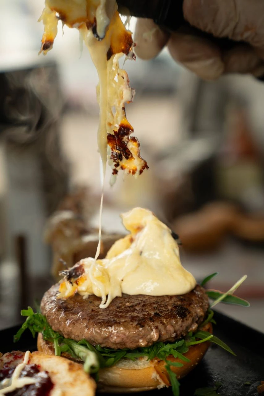 Frisch geschmolzener Raclettekäse auf einem Mr. Cheese Burger
